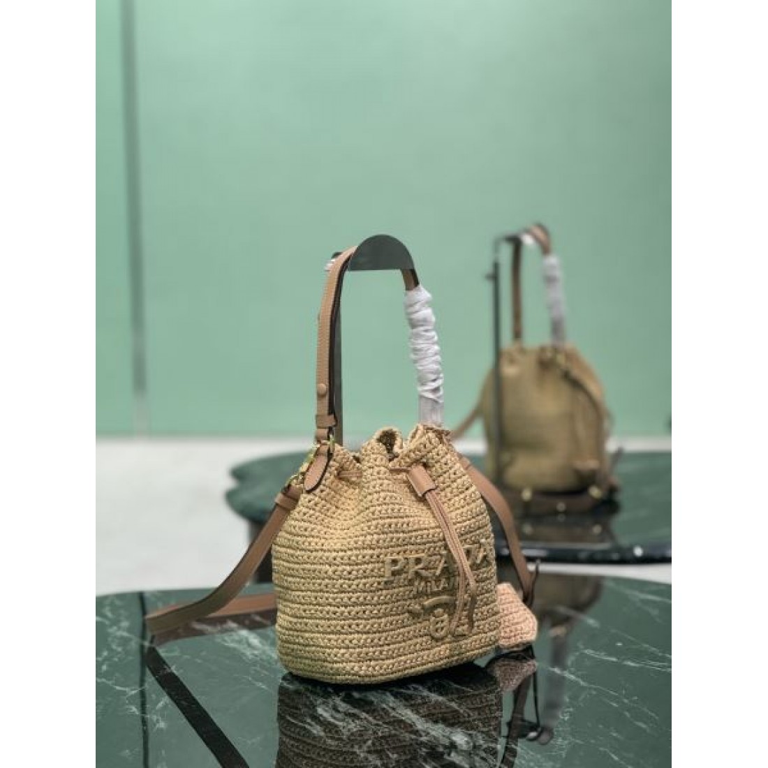 トレンド リゾート PRADA プラダ コピー ショルダーバッグ 編み込みバケット 巾着開閉 コンパクト収納 2WAY仕様 レザーストラップ 軽やか質感