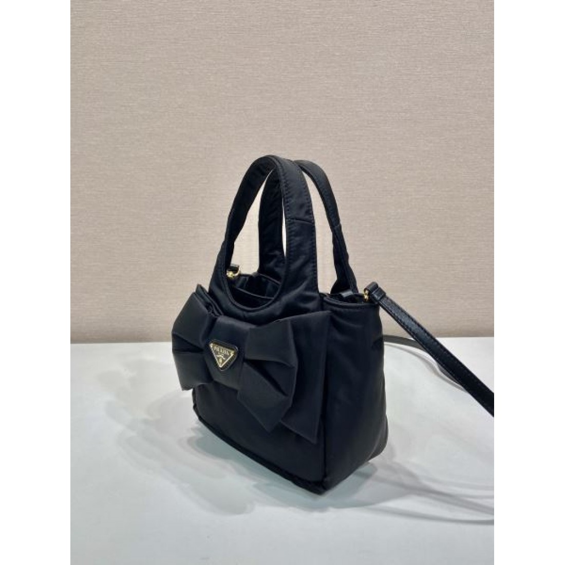 シンプル 洗練 PRADA プラダ コピー バッグ コンパクトハンドバッグ ナイロンボディ リボンディテール ロゴプレート 取り外し可能ストラップ 日常万能