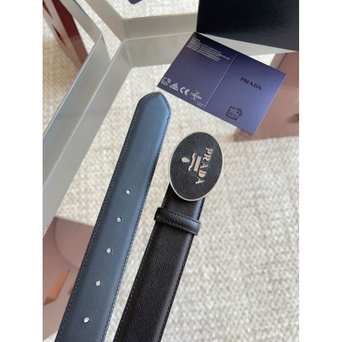 サフィアーノ調 Prada プラダ コピー ベルト ブラック型押しレザー ラウンドロゴバックル マット質感 スマートな印象 メンズ定番